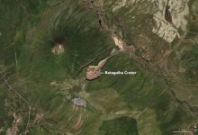 open arctic tundra terrain with low shrubs and thaw ponds